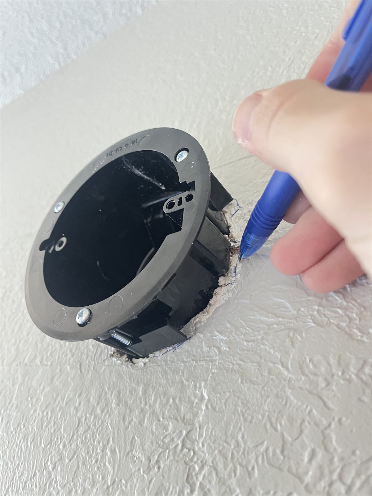 Tracing the outline of the box onto the wall with a pen