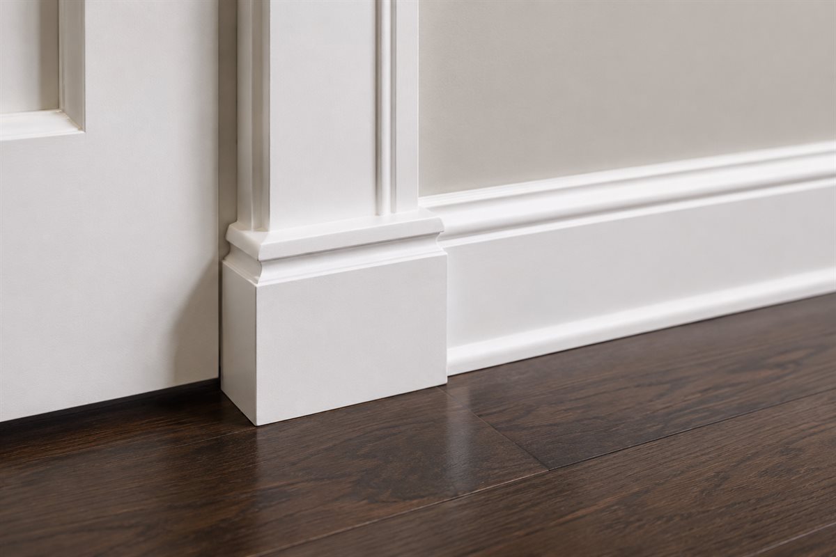Freshly installed white door trim, baseboard, and dark luxury vinyl plank flooring